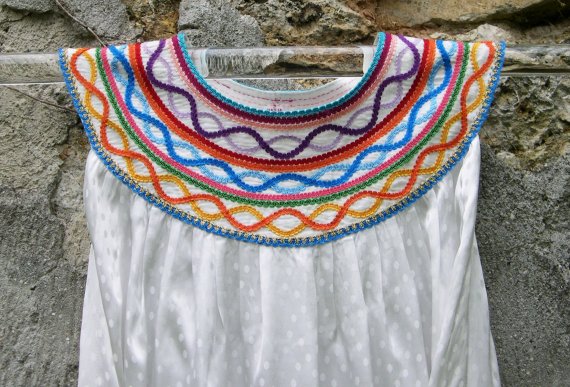 Robe blanche à galons en arrondi détail de l'encolure