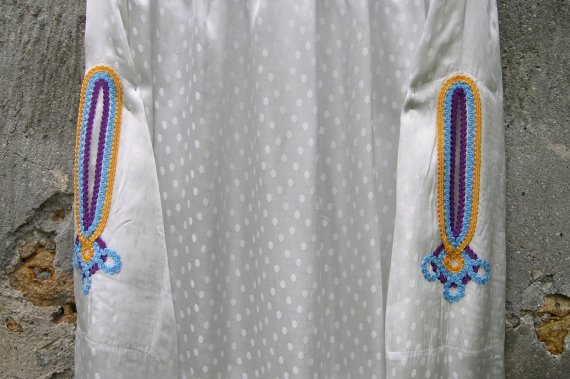 Robe blanche à galons en arrondi détail des poches galonnées